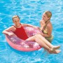 Mädchen mit rosa, glitzerndem Schwimmring im Pool. Badespaß mit der Schwimmhilfe.