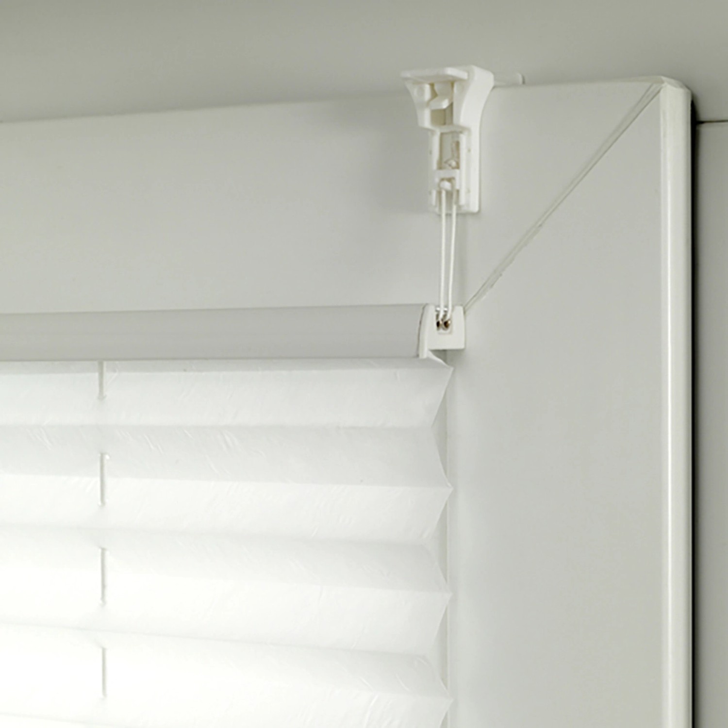 Detailaufnahme: Weißes Gardinia Plissee Bella Blätter, blickdicht, mit Klemmträger am Fenster.