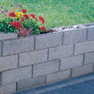 Graue Kann Gartenmauer aus Beton mit Bepflanzung als Grundstückseinfassung.