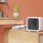 Kompakter, weißer Keramikheizer Nevala 2in1 mit Ventilator auf einem Tisch.