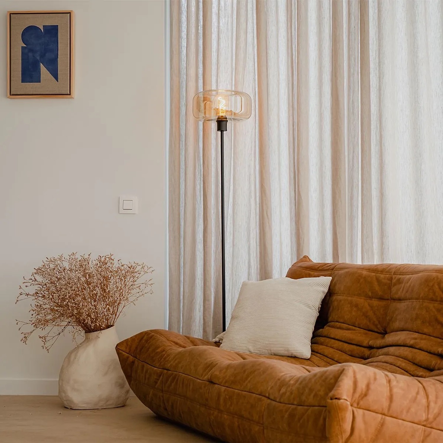 Art Deco Stehlampe Bizle in Schwarz und Braun mit bernsteinfarbenem Glas in Wohnzimmer.