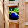 2-teiliges T & J Vogelhaus Aalborg aus Lärche, montiert an einem Holzzaun. Dekoriert mit einer blauen Kugel.
