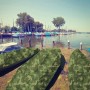 Boote abgedeckt mit KARAT Abdeckplane, wasserdicht, 100 g/m², Camouflage, am See.