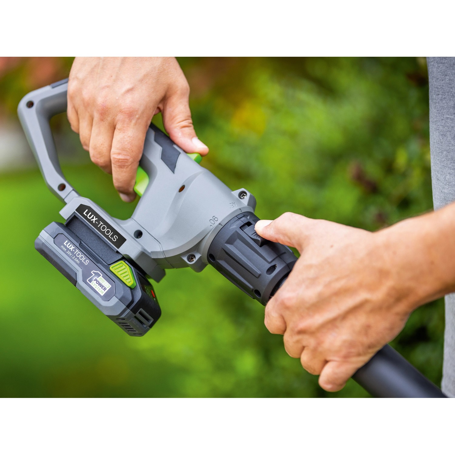 Nahaufnahme der LUX-TOOLS Akku-Heckenschere & Astsäge mit Akku im Einsatz.
