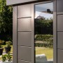 Modernes, graues Gerätehaus Classico Lounge XL mit Fenster und weißen Ecken im Garten.