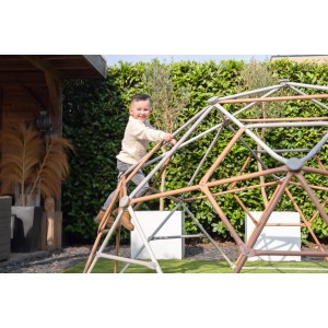 Kind klettert auf Exit Kletterkuppel Metal Climbing Dome Ø 300 cm im Garten.