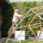 Kind klettert auf Exit Kletterkuppel Metal Climbing Dome Ø 300 cm im Garten.
