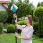 Frau benutzt Gardena combisystem Winkelbesen mit Stiel im Garten.