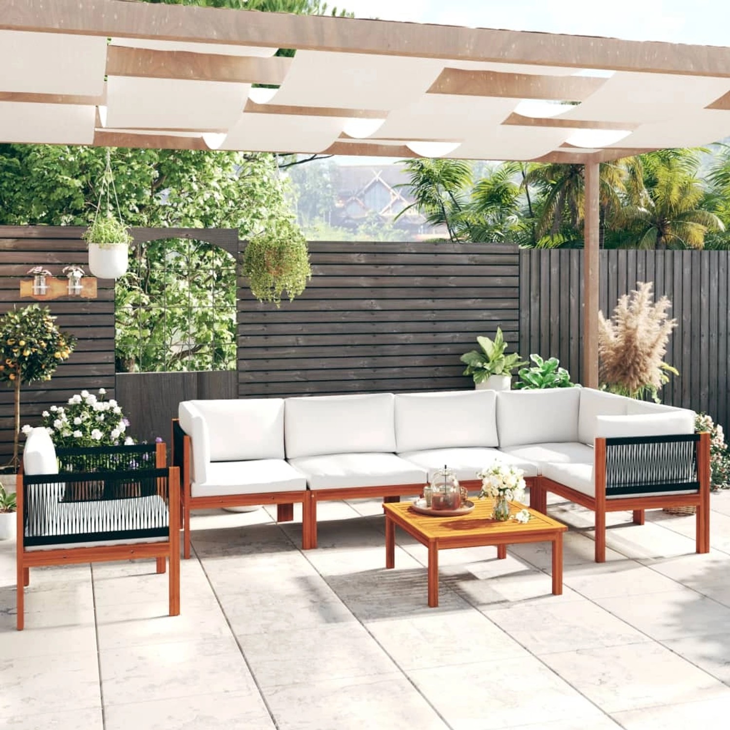 7-teiliges Garten Lounge Set aus Akazienholz mit cremefarbenen Kissen und Seilrückenlehne.