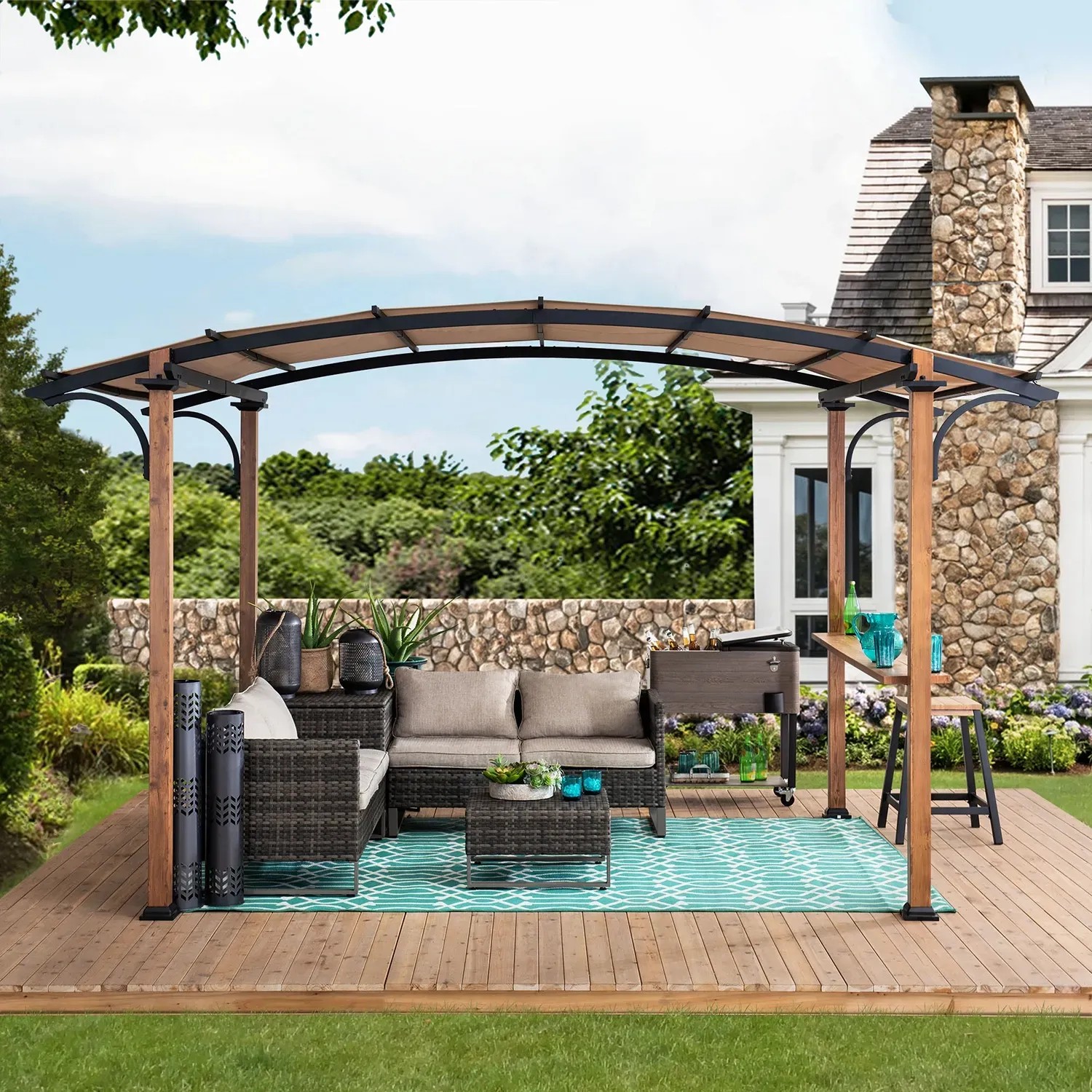 Sunjoy Pergola Skuta, 406x259 cm, beige Stoff, Holzoptik, mit Lounge-Möbeln auf Terrasse.