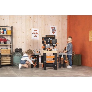 Smoby Black+Decker Mega Werkbank Center mit 3 Spielbereichen und Kindern beim Spielen.