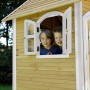 Axi Spielhaus Laura: Kinder schauen aus dem Fenster des braun-weißen Holz-Spielhauses.