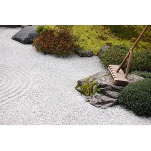 Weißer Marmor Splitt "Carrara" (9-12 mm) im Zen-Garten mit Rechen und Steinen.