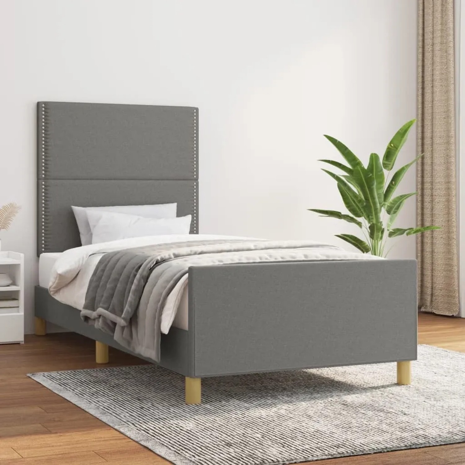 Dunkelgraues Stoff-Bettgestell (90x190 cm) mit Kopfteil im Schlafzimmer.
