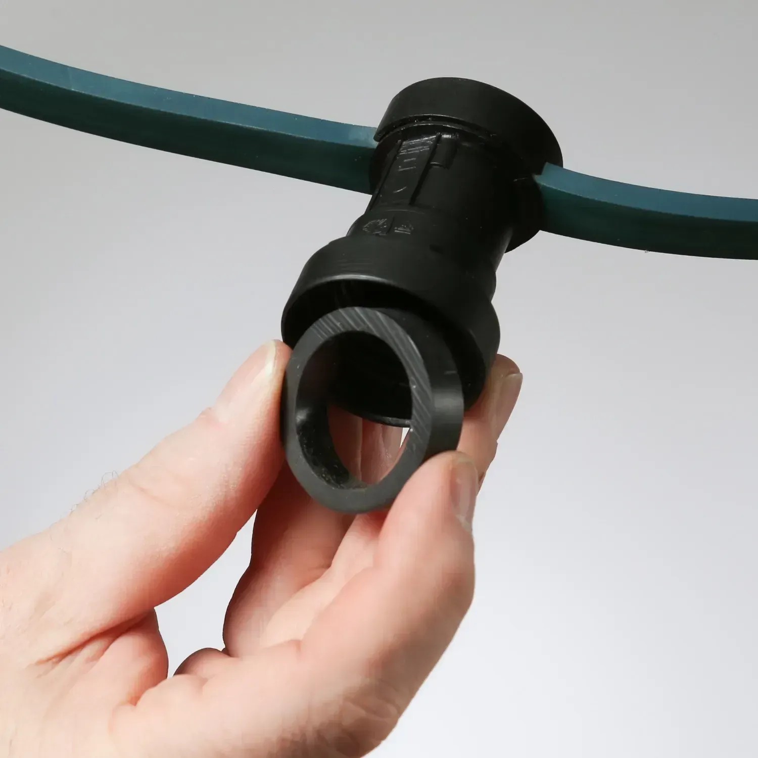 Detailaufnahme einer Fassung der Satisfire Illu Lichterkette mit Dichtungsring in der Hand.