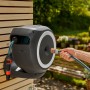 Gardena Wand-Schlauchbox RollUp M mit 20 m Schlauch an Holzwand, Gartenschlauchwagen.