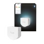Weißes Philips Hue Wandschaltermodul 1C mit schwarzer Verpackung. Macht Standard-Lampen smart über Netzbetrieb.