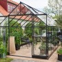 Schwarzes Halls Gewächshaus Qube+ 816 mit 13 m² Fläche im Garten.