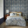 Schlafzimmer mit blauer William Morris Vliestapete Pimpernel mit floralem Muster.