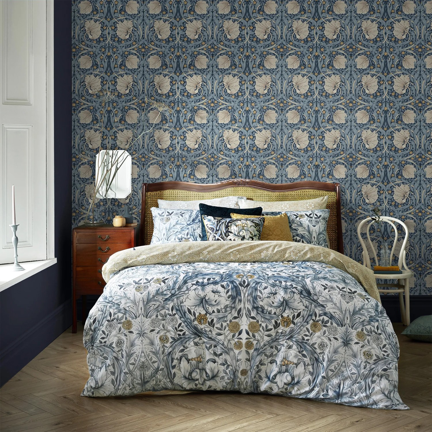 Schlafzimmer mit blauer William Morris Vliestapete Pimpernel mit floralem Muster.