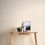 A.S. Création Vliestapete mit kreisförmigem Bogenmuster in Beige und Weiß an einer Wand.
