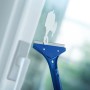 LUX Fenster- und Bodenschaber im Einsatz zum Entfernen von Farbresten auf einer Fensterscheibe.
