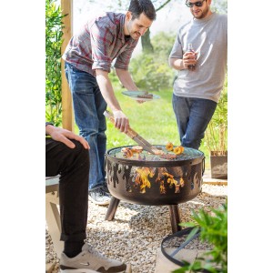 Buschbeck Feuerkorb Wildfire mit Grillfunktion im Einsatz mit Personen beim Grillen.