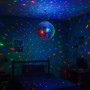 Silberne Discokugel mit Glasfacetten hängt von der Decke und erzeugt bunte Lichtreflexionen im Raum.