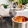Feuerhand Pyron Feuertonne aus Edelstahl, 25 l, mit brennendem Feuer im Garten.