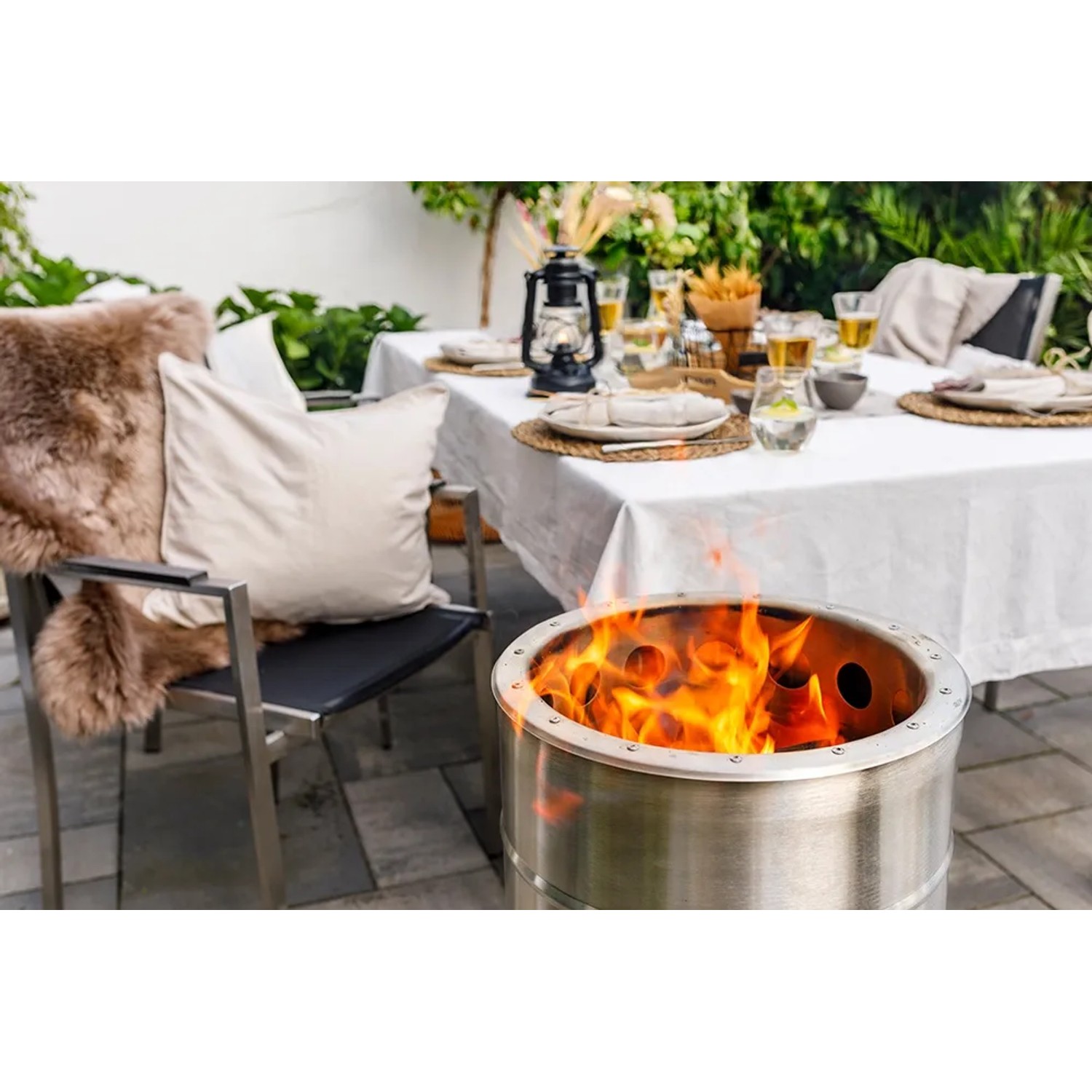 Feuerhand Pyron Feuertonne aus Edelstahl, 25 l, mit brennendem Feuer im Garten.