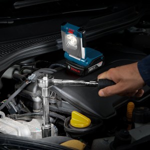 Bosch Professional Akku-Lampe GLI VariLED im Einsatz am Motorraum, beleuchtet Werkzeug.