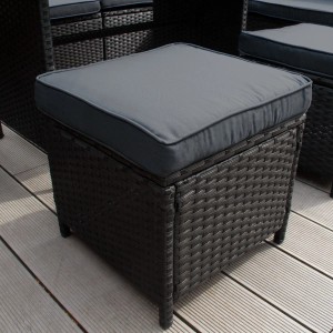 Hocker des schwarzen Polyrattan Gartenmöbel Sets mit grauem Kissen.