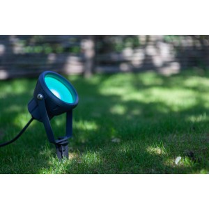 Lutec LED-Erdspieß Mini Leto, anthrazitfarbiger Gartenstrahler mit grünem Licht im Rasen.