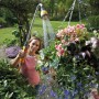 Frau bewässert Blumen mit Hozelock Flexi Spray 4in1 Gartenbrause.