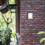 Quadratische Philips myGarden LED-Außenwandleuchte Karp in Anthrazit an einer Backsteinwand.