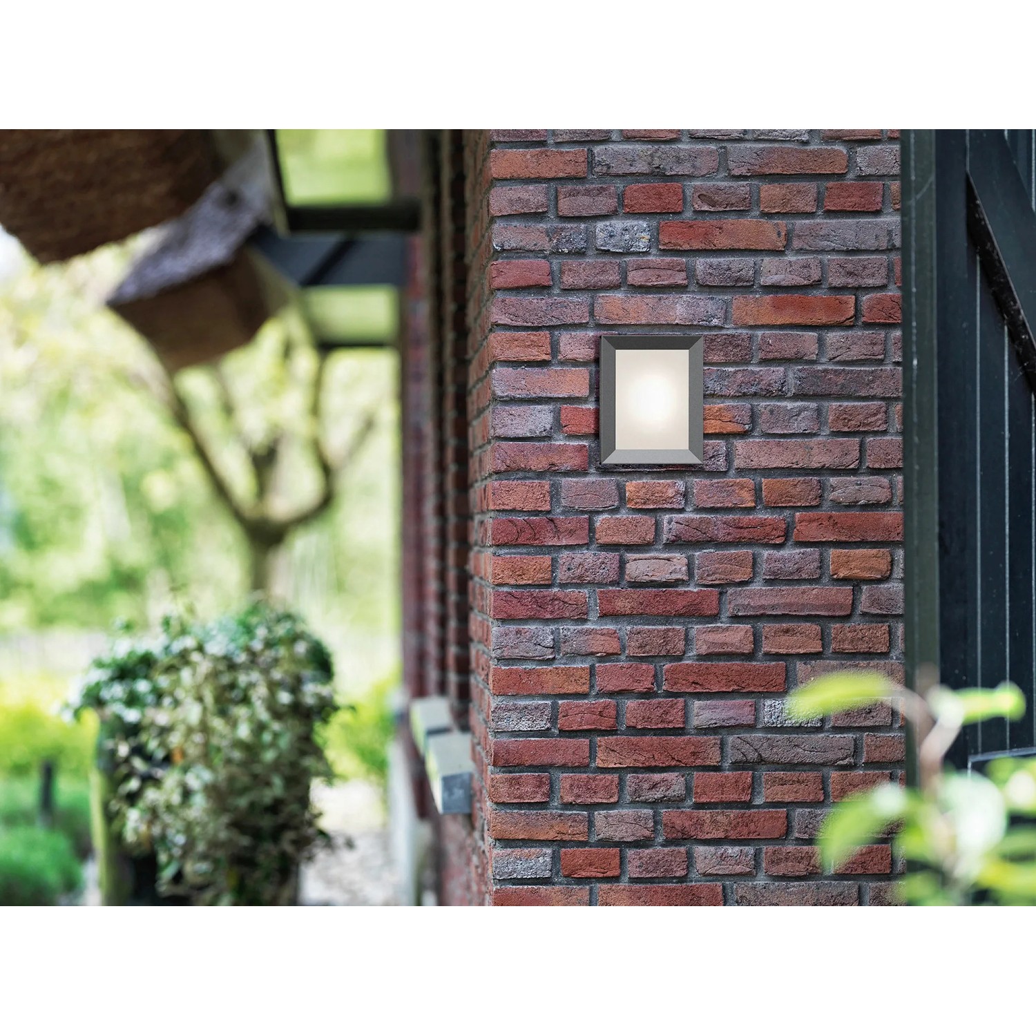 Quadratische Philips myGarden LED-Außenwandleuchte Karp in Anthrazit an einer Backsteinwand.