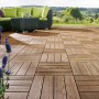 Verlegte, braune WPC Klickfliesen in Holzoptik auf einer Terrasse mit Gartenmöbeln.