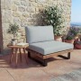 MCW Lounge-Sessel H54 aus hellbraunem Akazienholz mit hellgrauen Polstern auf einer Terrasse.