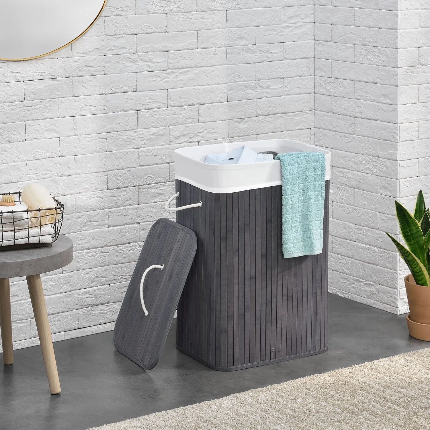 Grauer Bambus Wäschekorb (72L) mit Wäschesack und Deckel im Badezimmer.