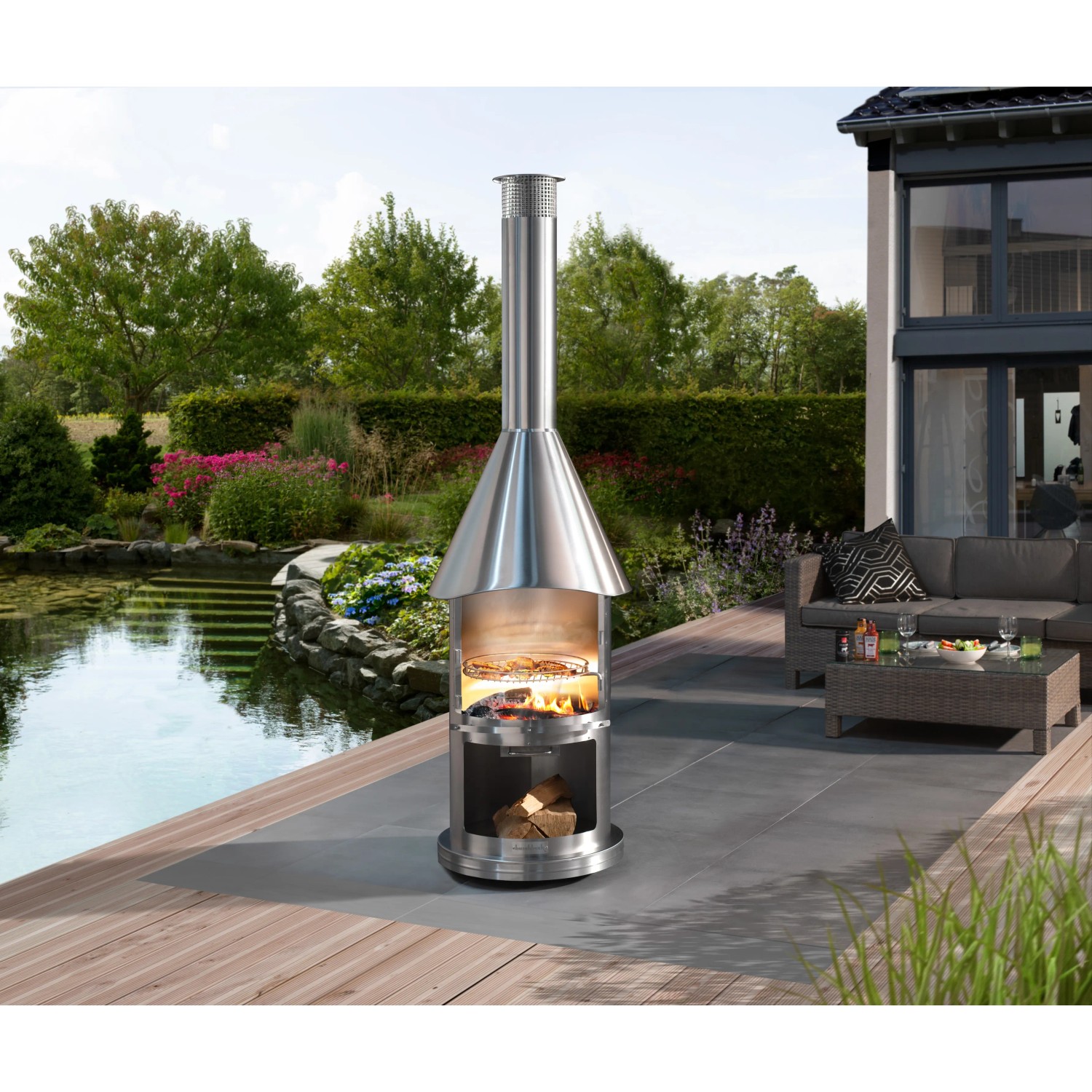 Buschbeck Edelstahlgrill Auckland, gebürsteter Edelstahl, mit Feuer und Grillrost im Garten.