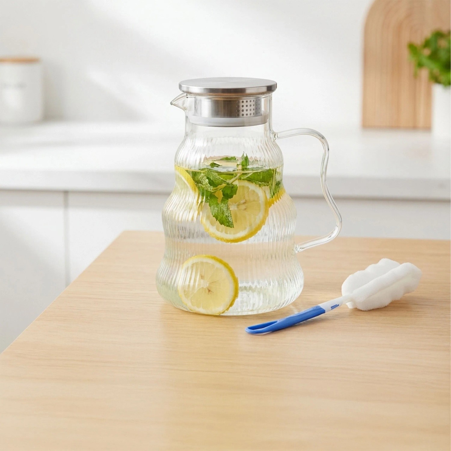 Transparente Glaskaraffe aus Borosilikatglas mit geriffelter Optik, gefüllt mit Wasser, Zitrone und Minze. Inkl. Reinigungsbürste.