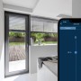 Smartphone zeigt Bosch Smart Home App zur Rollladensteuerung. Jalousien im modernen Raum auf 48% Position.