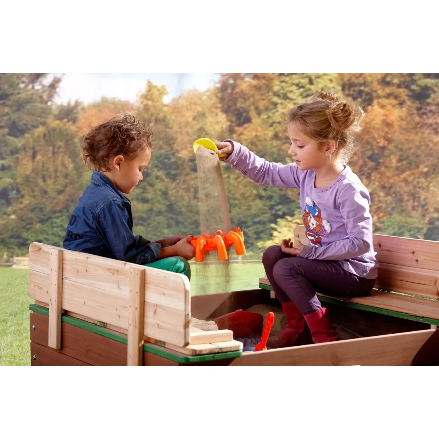 Axi Ella Sandkasten aus Holz mit zwei Kindern beim Spielen im Garten.