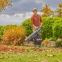 Gardena Akku-Laubsauger/-bläser PowerJetCollect Solo im Einsatz im Garten mit fallendem Laub.