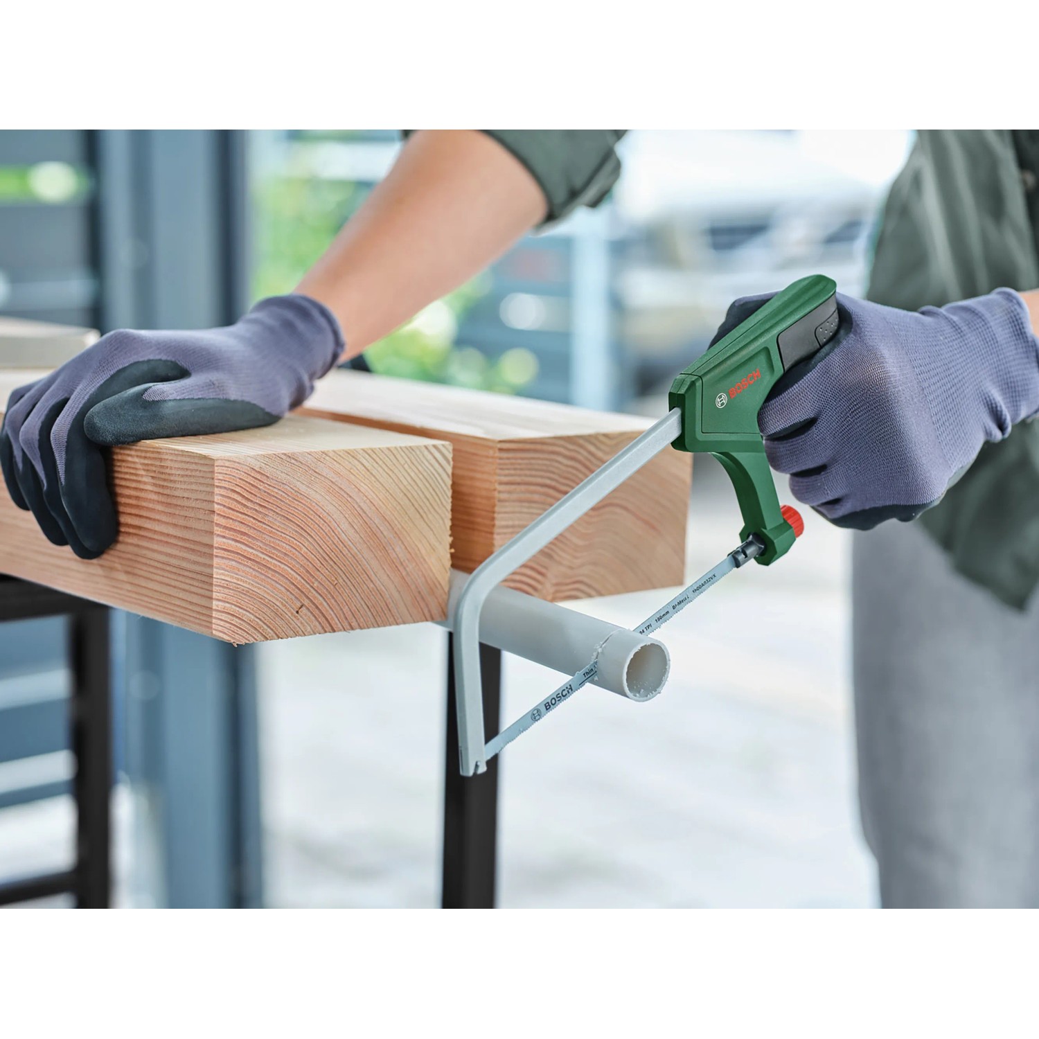 Bosch Bügelsäge 15 cm schneidet Kunststoffrohr. Handsäge mit grünem Griff und Metallsägeblatt.