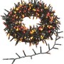 OBI Lichterkette mit 700 mehrfarbigen LEDs auf grünem Kabel, aufgerollt und teilweise ausgelegt, ideal für Garten & Terrasse.