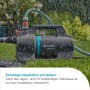 Gardena Gartenpumpe 5200 Silent im Einsatz, mit Schlauch auf Rasen unter Regen.