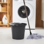 Anthrazitfarbener Rotho Skaleneimer Daily 10 l mit Putzlappen und Wischmopp vor Waschmaschine.