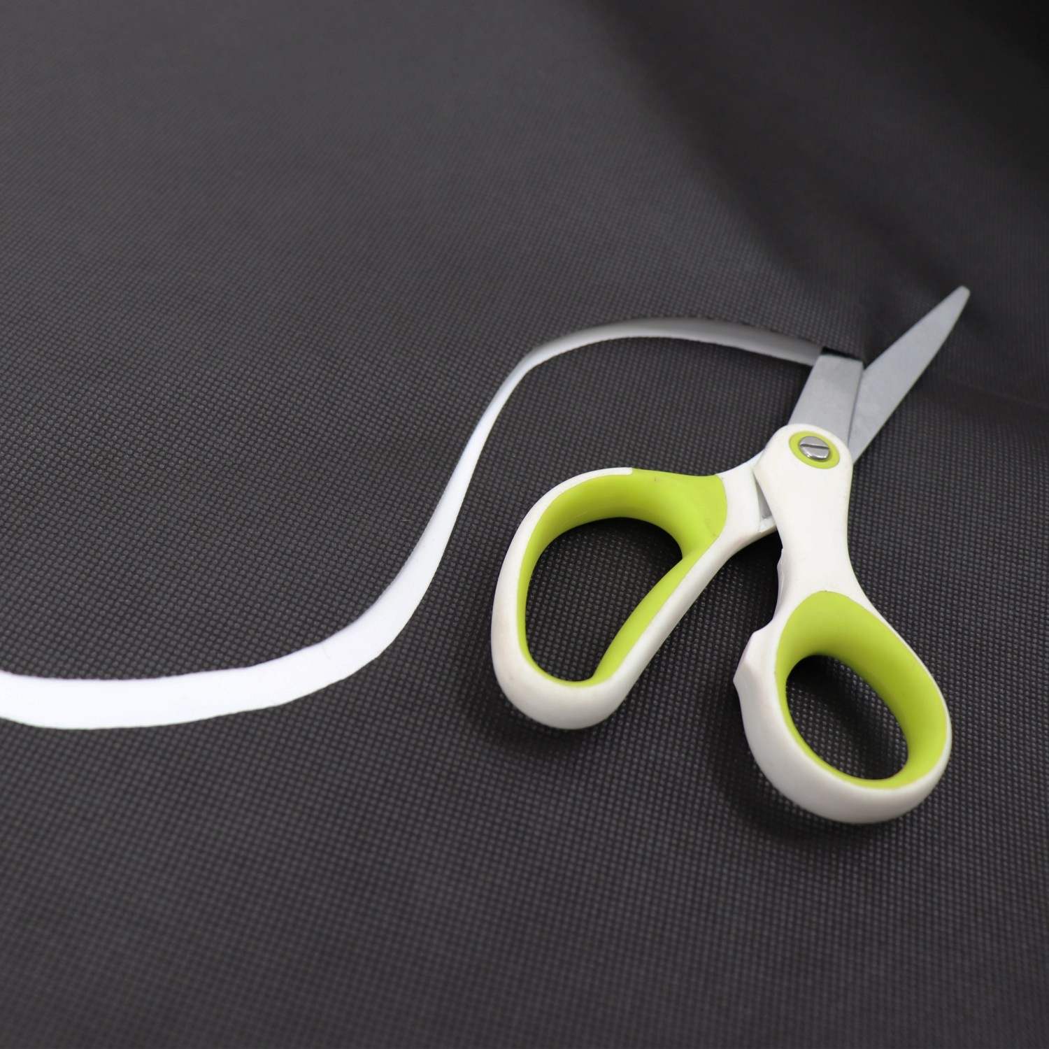 Aquagart Unkrautvlies 100g, 1,8m breit, wird mit einer Schere zugeschnitten.