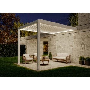 Wandmontierte, weiße Huun Pergola Mezzo 300x400 cm mit LED-Beleuchtung und Gartenmöbeln.